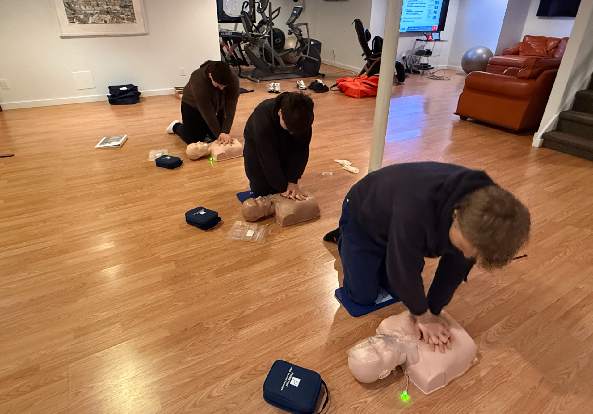 A CPR class practicing chest compressions on training manikins